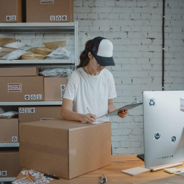 Image of an entrepreneur girl holding a clipboard ready to ship a package.