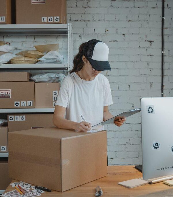 Image of an entrepreneur girl holding a clipboard ready to ship a package.