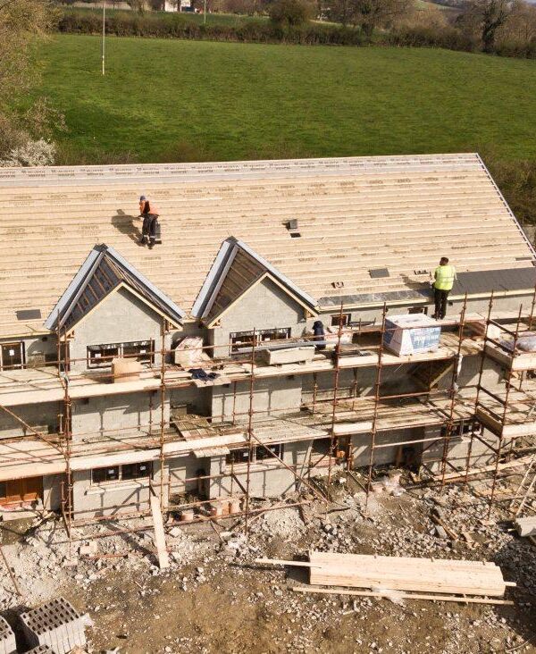 A house where the roof is being installed from top view.